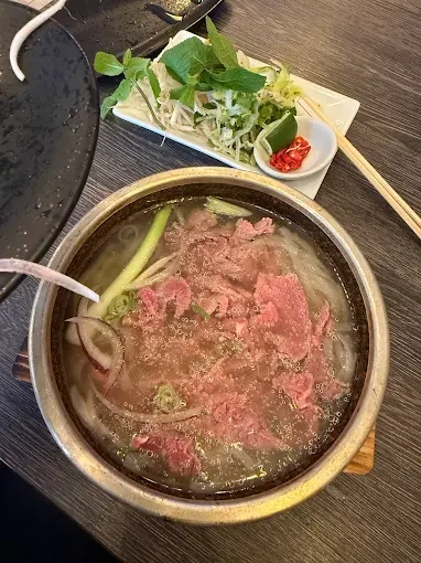 A bowl of Vietnamese pho with fresh herbs